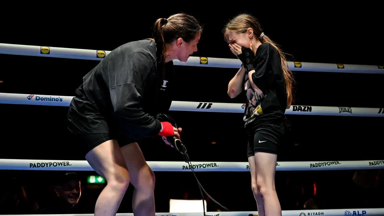 Boxeadora conversando con una niña en el ring Boxeadora conversando con una niña en el ring