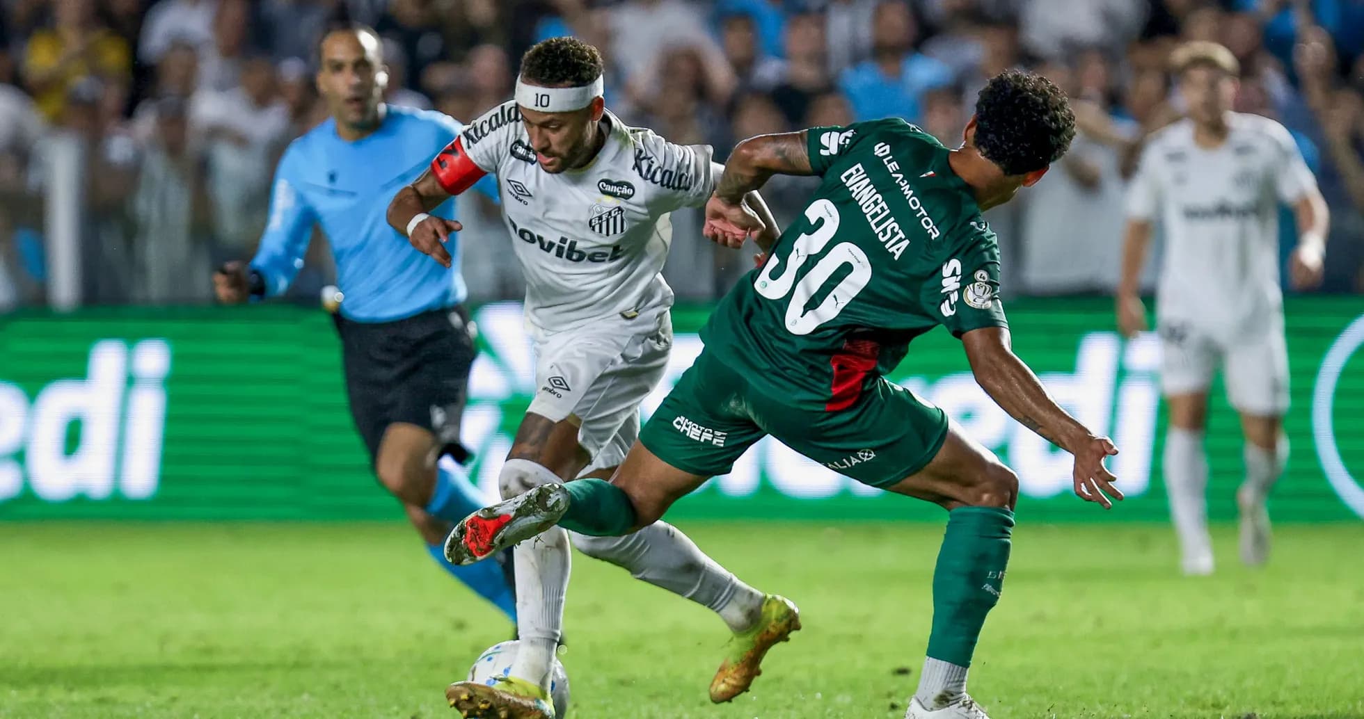 Jugador de Santos driblando a defensor rival en partido Jugador de Santos driblando a defensor rival en partido