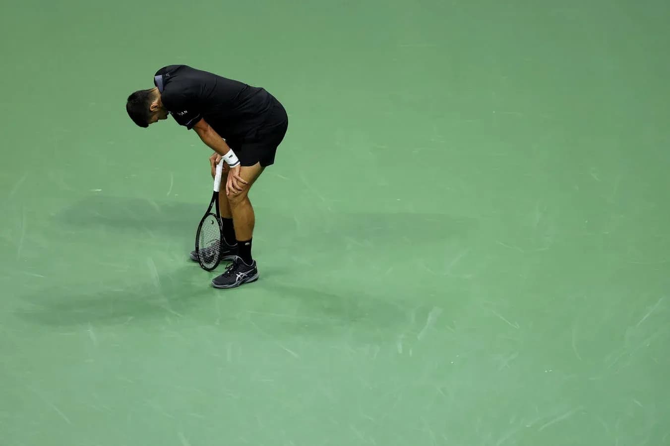 Jugador de tenis con raqueta, mostrando agotamiento Jugador de tenis con raqueta, mostrando agotamiento