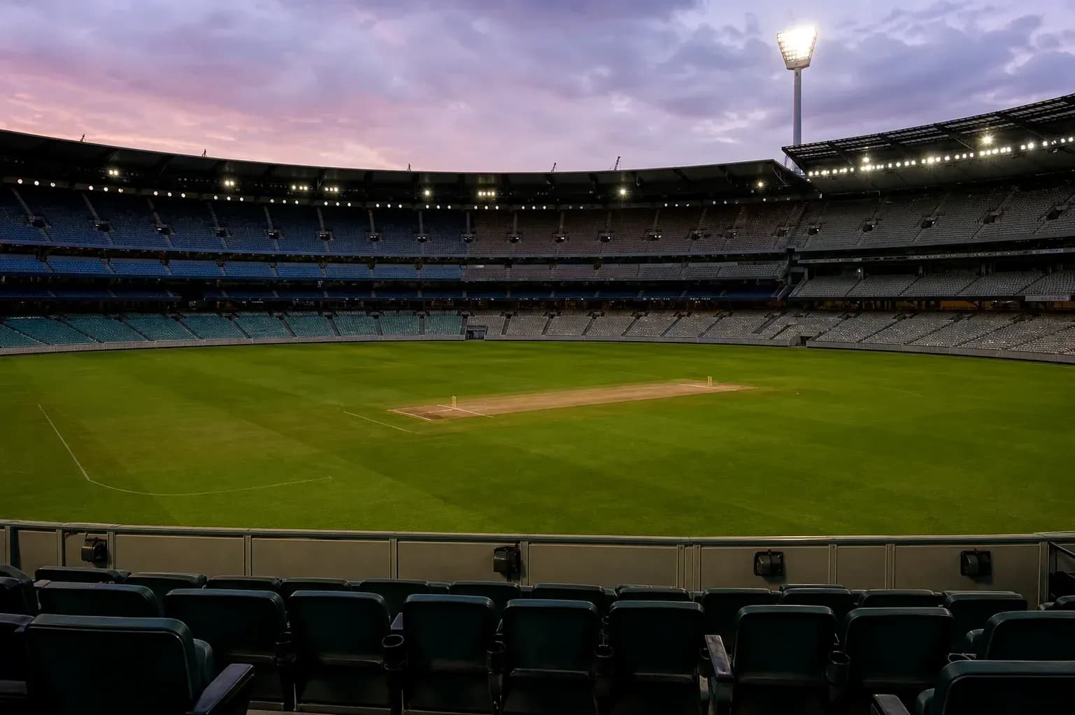 Estadio vacío con campo de cricket iluminado Estadio vacío con campo de cricket iluminado