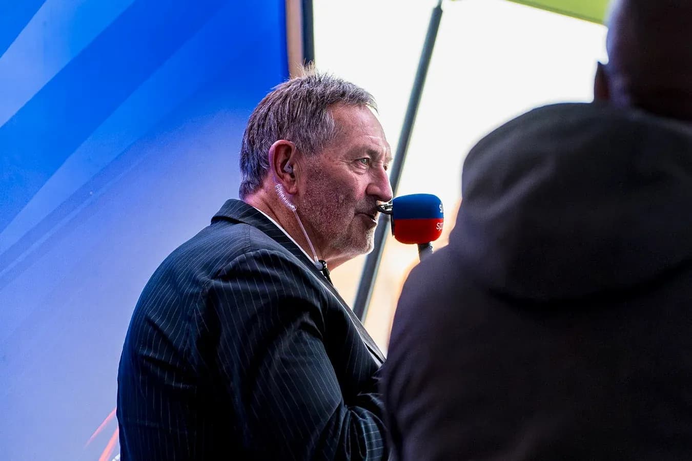 Hombre hablando por micrófono en un evento deportivo Hombre hablando por micrófono en un evento deportivo