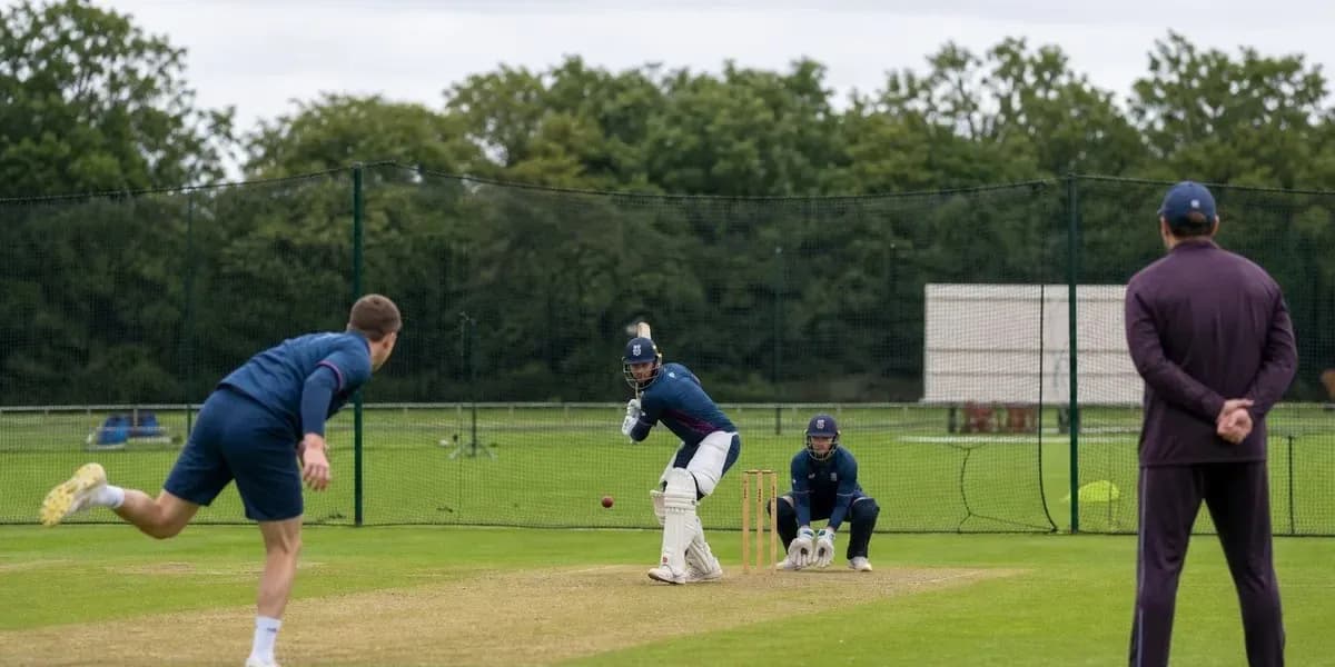 Jugador bateando mientras otro lanza en práctica de cricket Jugador bateando mientras otro lanza en práctica de cricket