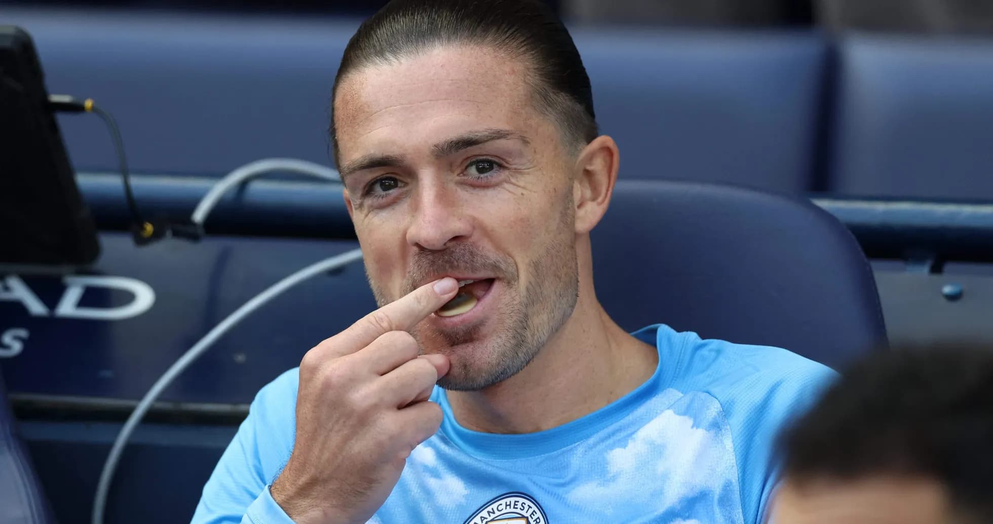 Jugador de Manchester City comiendo en el banquillo Jugador de Manchester City comiendo en el banquillo