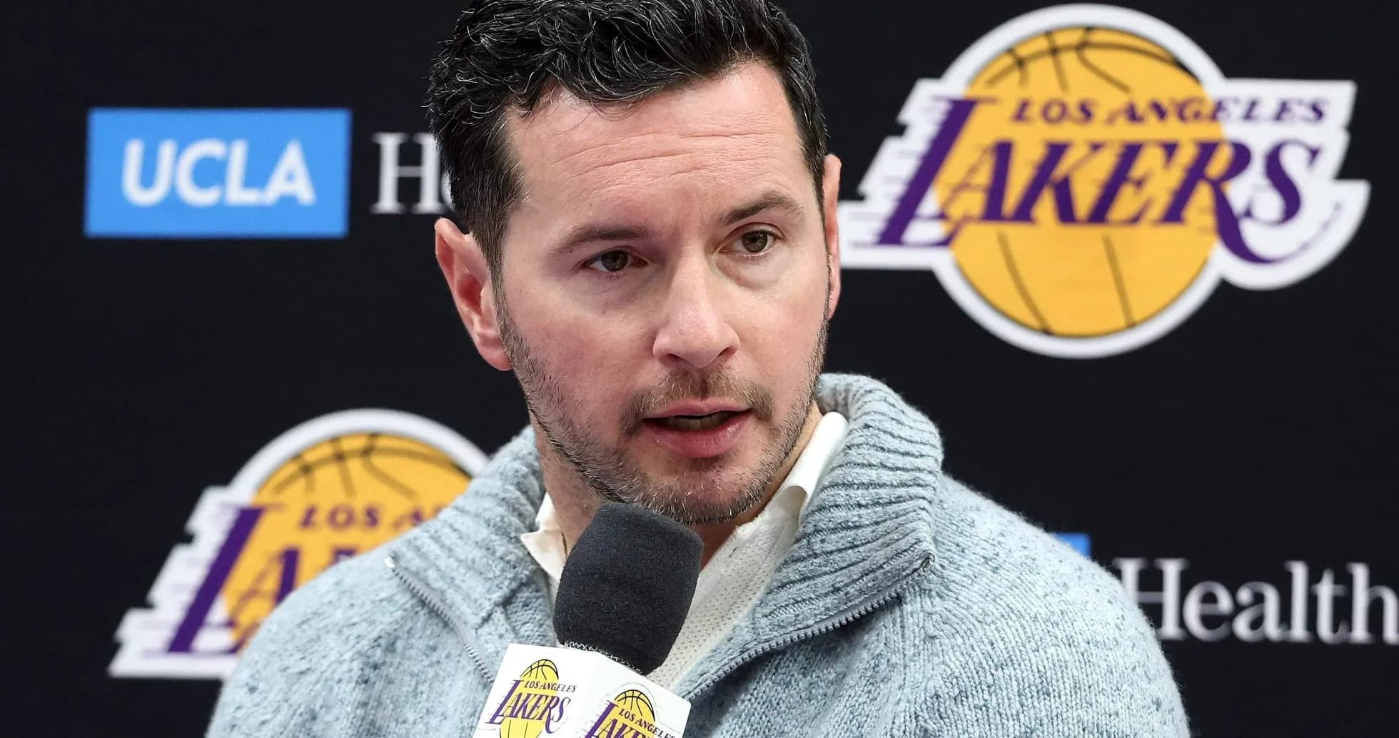 Hombre hablando en conferencia de prensa de los Lakers Hombre hablando en conferencia de prensa de los Lakers