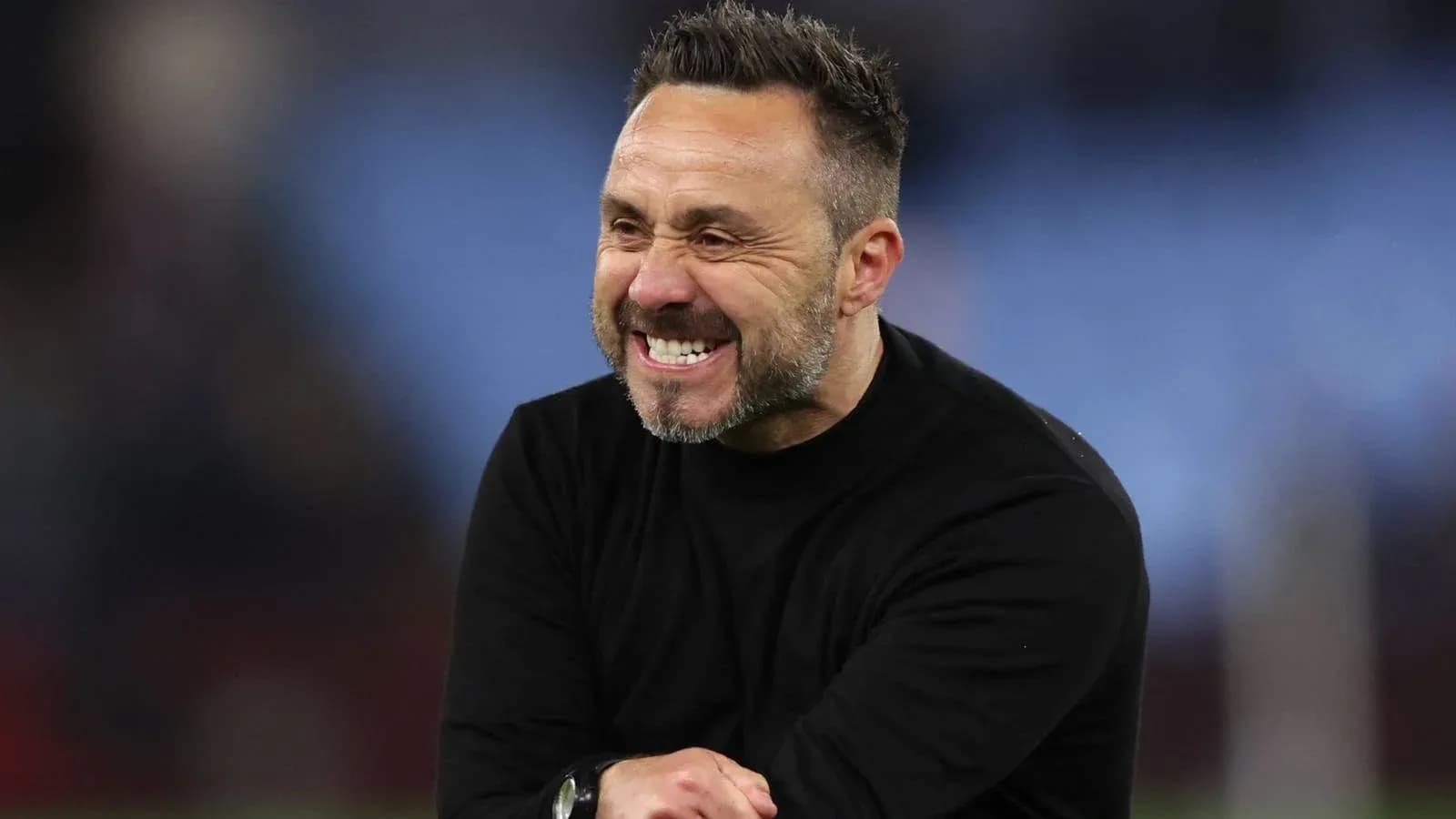 Entrenador sonriente en el campo durante el partido Entrenador sonriente en el campo durante el partido