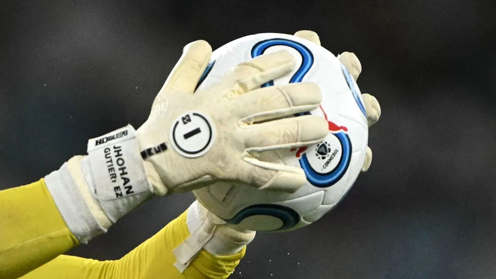 Portero sosteniendo el balón con guantes Portero sosteniendo el balón con guantes