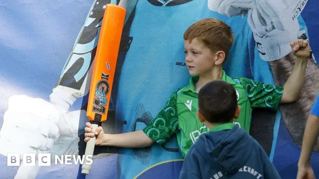 Niño sosteniendo un bate de cricket junto a un mural Niño sosteniendo un bate de cricket junto a un mural