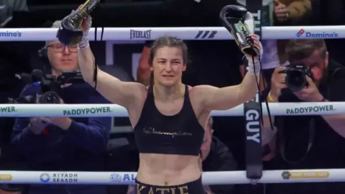 Katie Taylor levantando guantes tras victoria en combate Katie Taylor levantando guantes tras victoria en combate