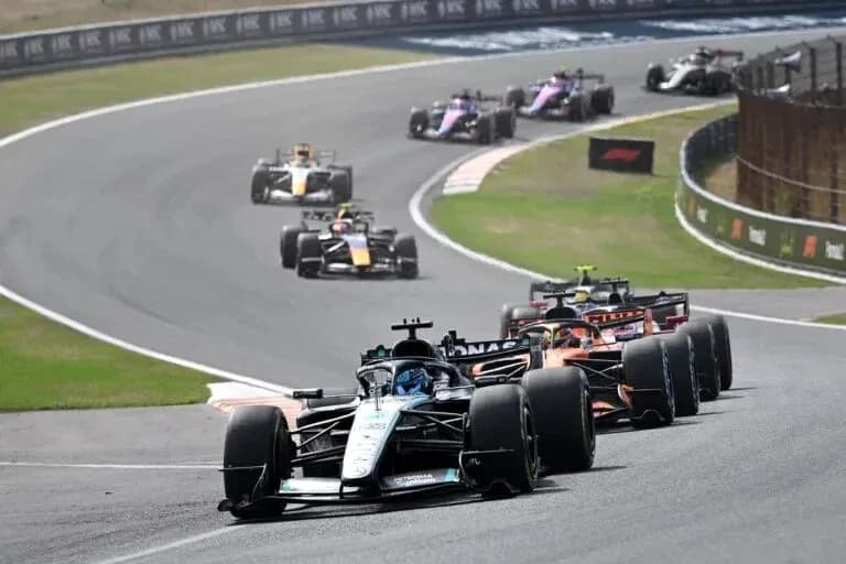 Varios coches de Fórmula 1 en una curva Varios coches de Fórmula 1 en una curva