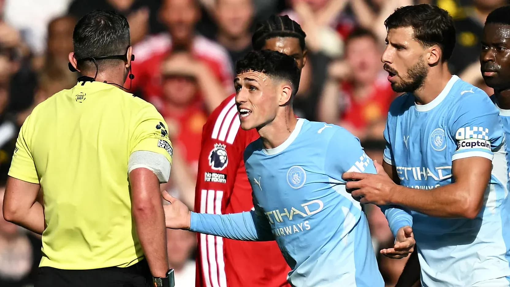 Jugador de Manchester City discutiendo con el árbitro Jugador de Manchester City discutiendo con el árbitro