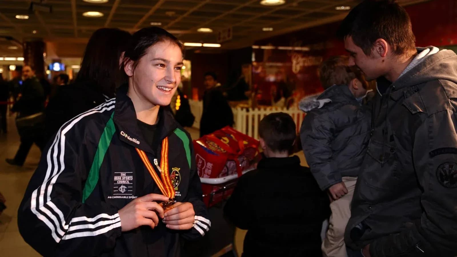 Atleta sonriente con medalla en aeropuerto Atleta sonriente con medalla en aeropuerto