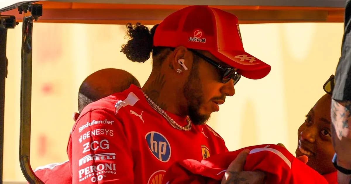 Lewis Hamilton con gorra de Ferrari interactuando con persona Lewis Hamilton con gorra de Ferrari interactuando con persona