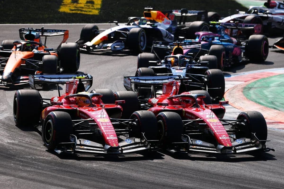 Dos coches Ferrari compitiendo en una curva de carrera Dos coches Ferrari compitiendo en una curva de carrera