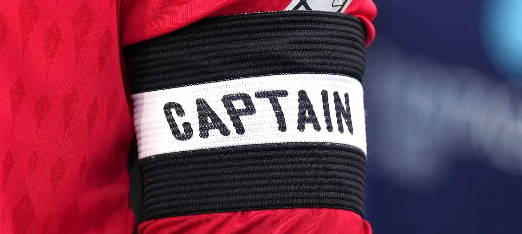 Brazo con cinta de capitán en uniforme deportivo Brazo con cinta de capitán en uniforme deportivo