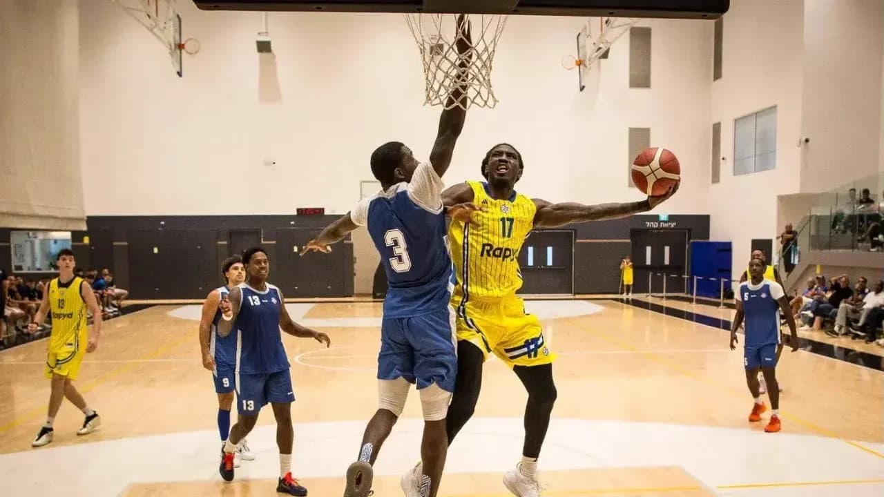 Jugador encestando mientras es defendido en baloncesto Jugador encestando mientras es defendido en baloncesto