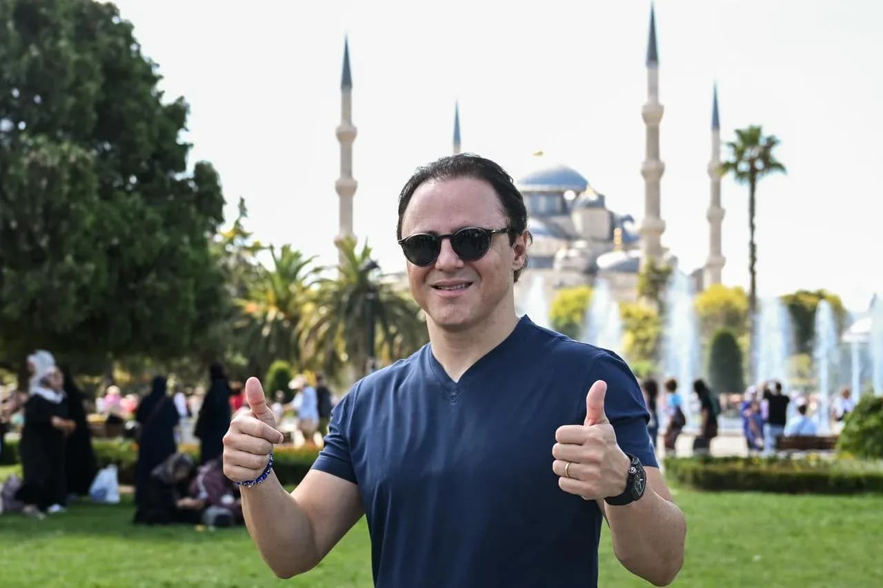 Hombre sonriendo con pulgares hacia arriba en parque Hombre sonriendo con pulgares hacia arriba en parque