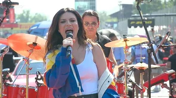 Cantante actuando en un escenario con banda Cantante actuando en un escenario con banda