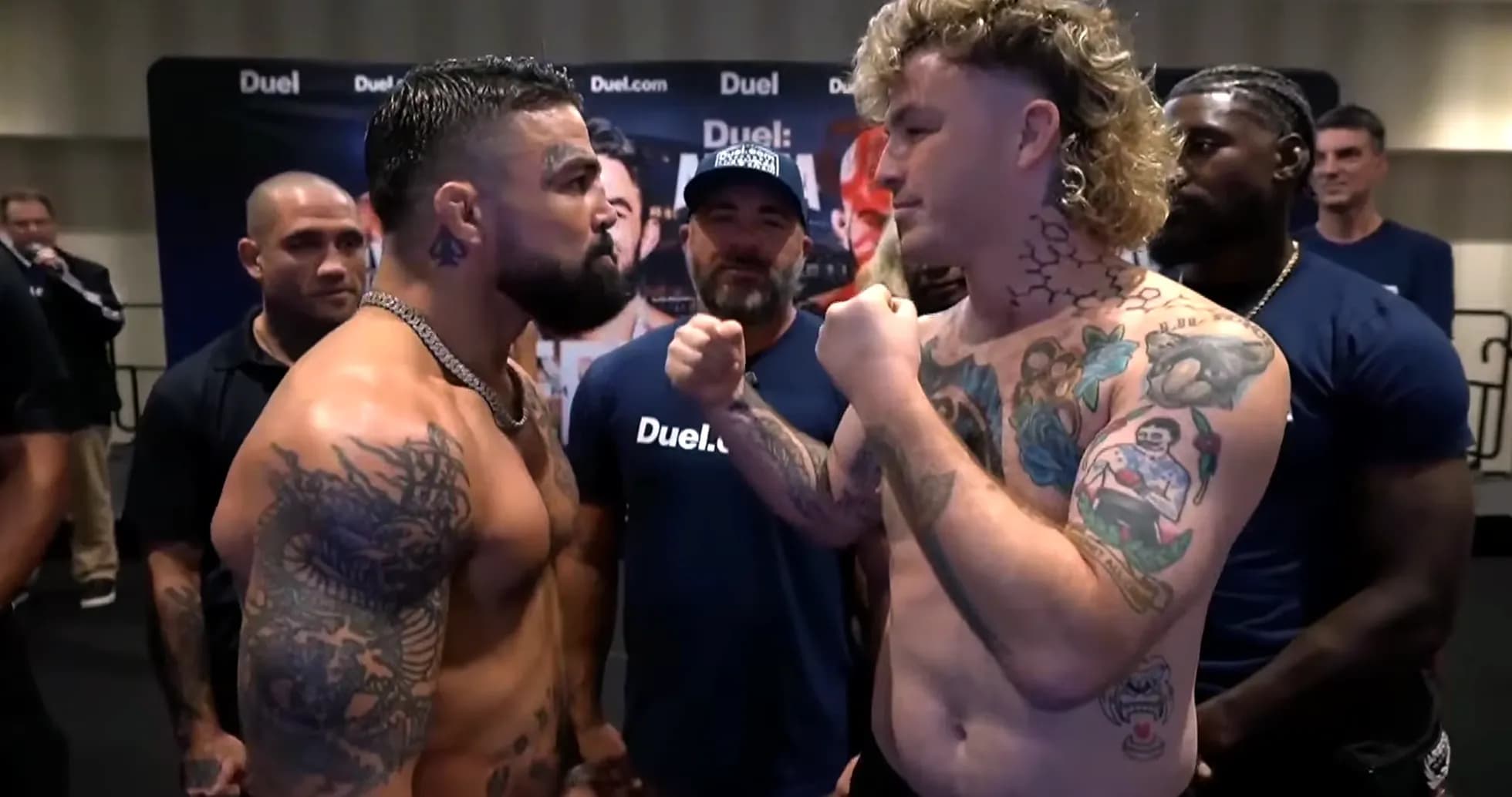 Dos luchadores enfrentándose durante la ceremonia de pesaje Dos luchadores enfrentándose durante la ceremonia de pesaje