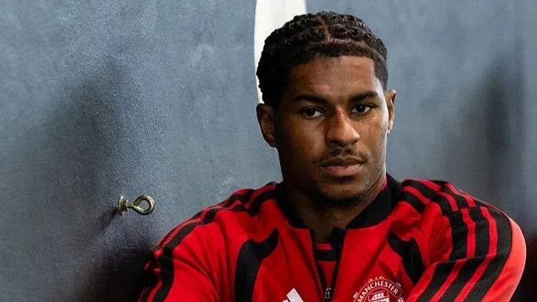 Jugador sentado en el vestuario con camiseta roja Jugador sentado en el vestuario con camiseta roja