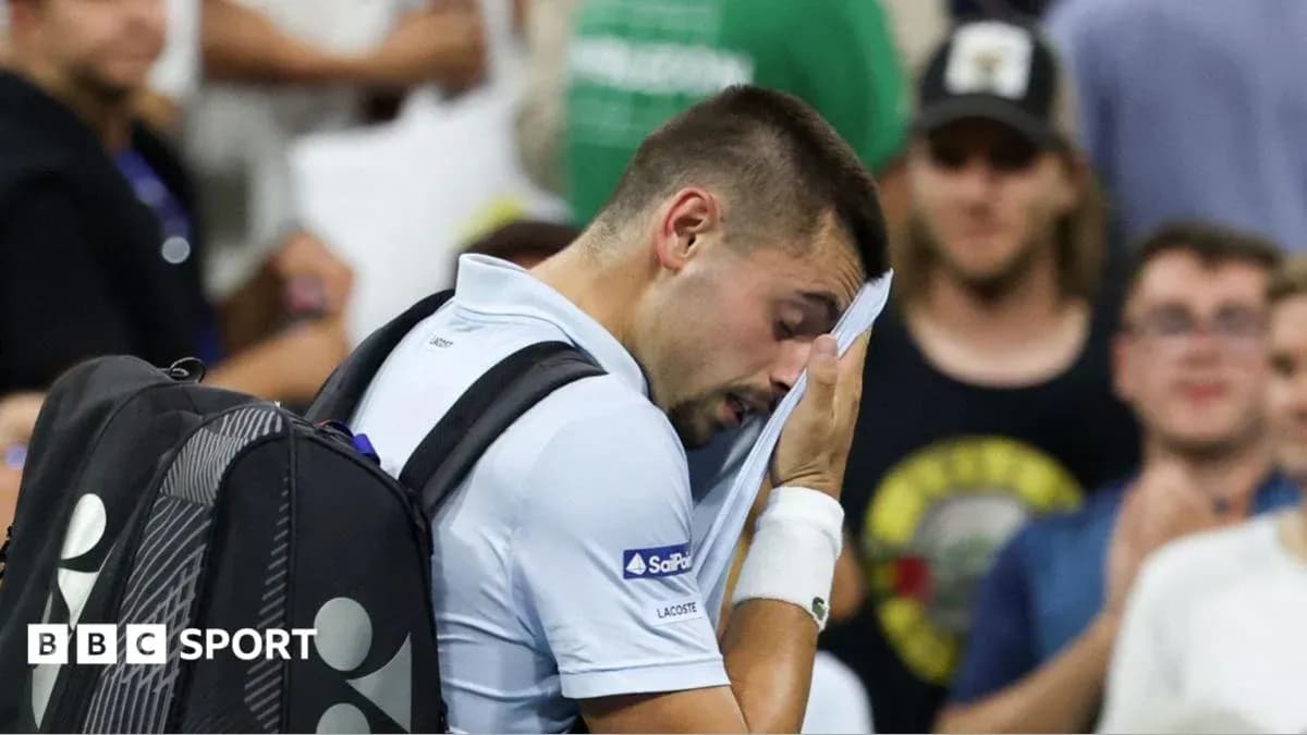 Jugador de tenis secándose la cara durante el partido Jugador de tenis secándose la cara durante el partido
