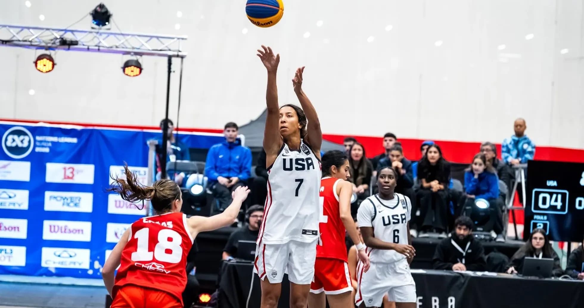 Jugadora de USA lanzando balón en partido de baloncesto Jugadora de USA lanzando balón en partido de baloncesto