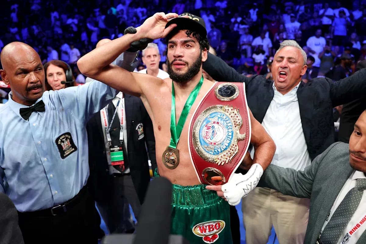 Boxeador sosteniendo cinturón de campeón tras victoria Boxeador sosteniendo cinturón de campeón tras victoria