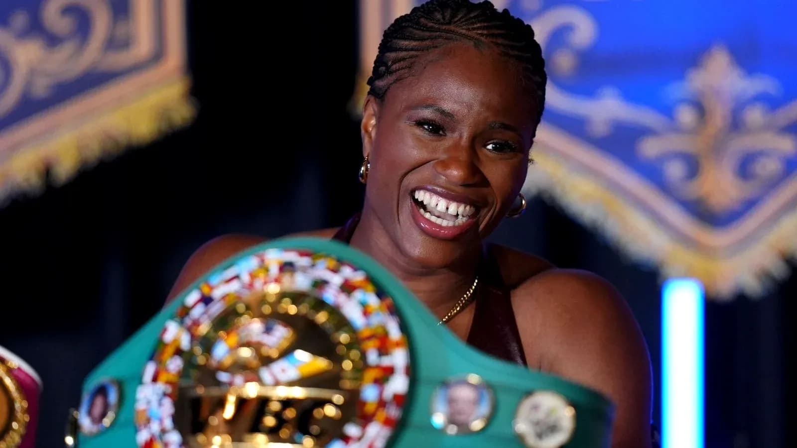Boxeadora sosteniendo cinturón de campeona con sonrisa Boxeadora sosteniendo cinturón de campeona con sonrisa