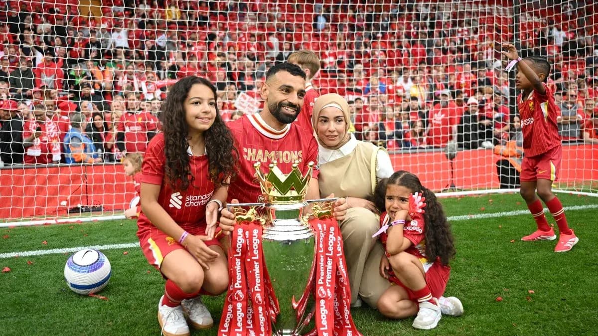 Jugador con trofeo y su familia en el campo Jugador con trofeo y su familia en el campo