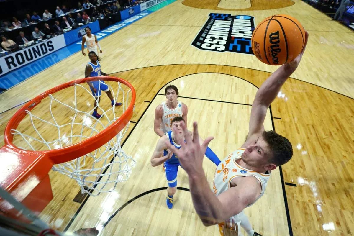 Jugador realizando un mate en partido de baloncesto Jugador realizando un mate en partido de baloncesto