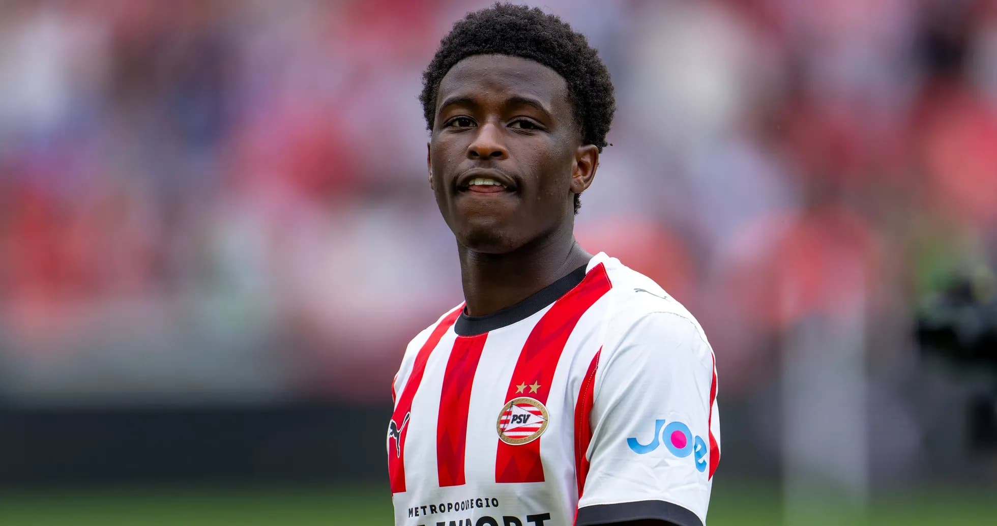 Jugador de PSV con camiseta blanca y roja en campo Jugador de PSV con camiseta blanca y roja en campo