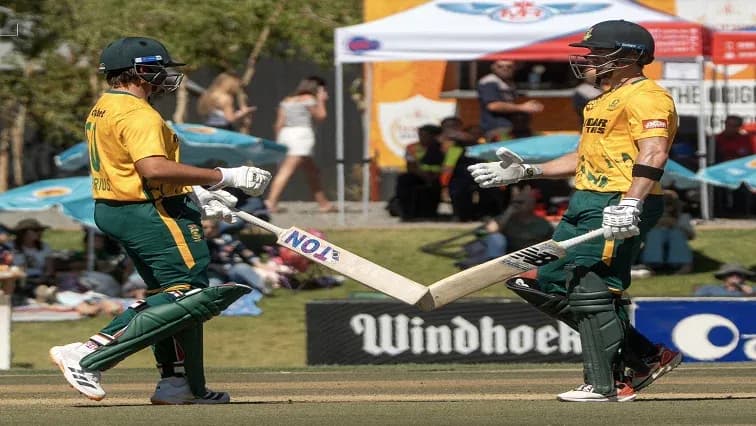 Jugadores chocando bates durante partido de cricket Jugadores chocando bates durante partido de cricket