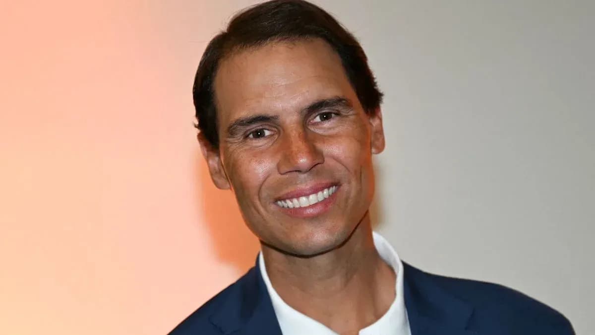 Hombre sonriendo en evento con fondo naranja Hombre sonriendo en evento con fondo naranja