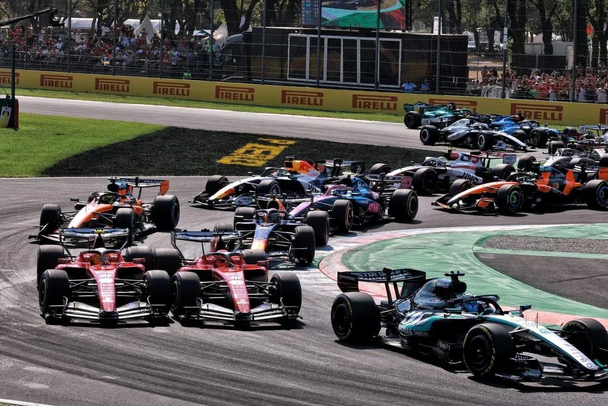 Varios coches de F1 compitiendo en curva durante carrera Varios coches de F1 compitiendo en curva durante carrera