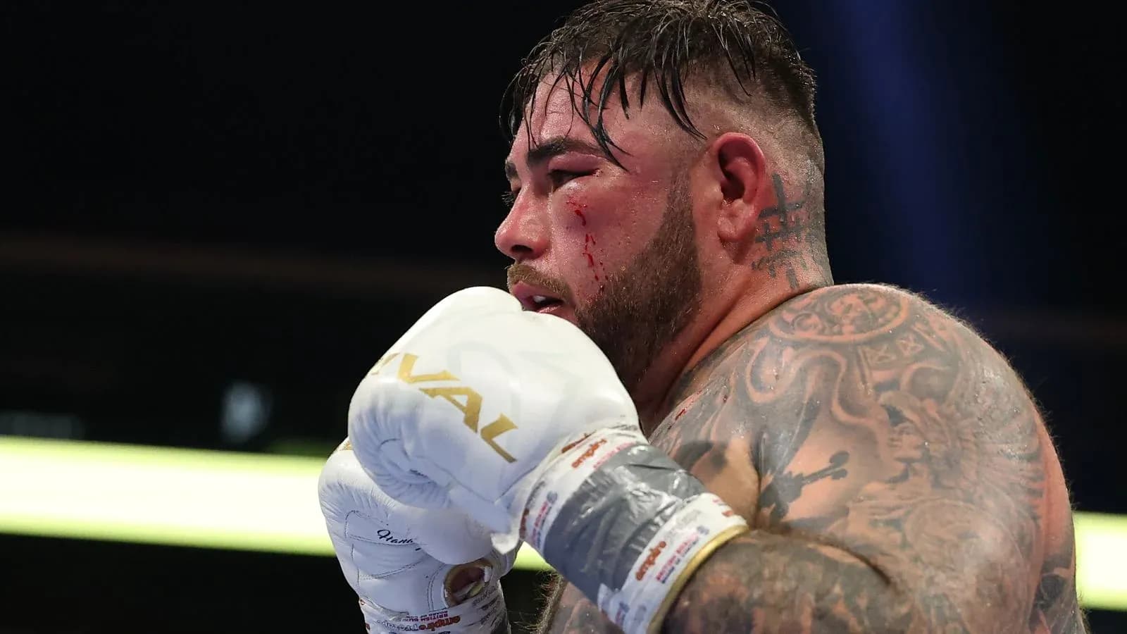 Boxeador con guantes y heridas en el rostro Boxeador con guantes y heridas en el rostro