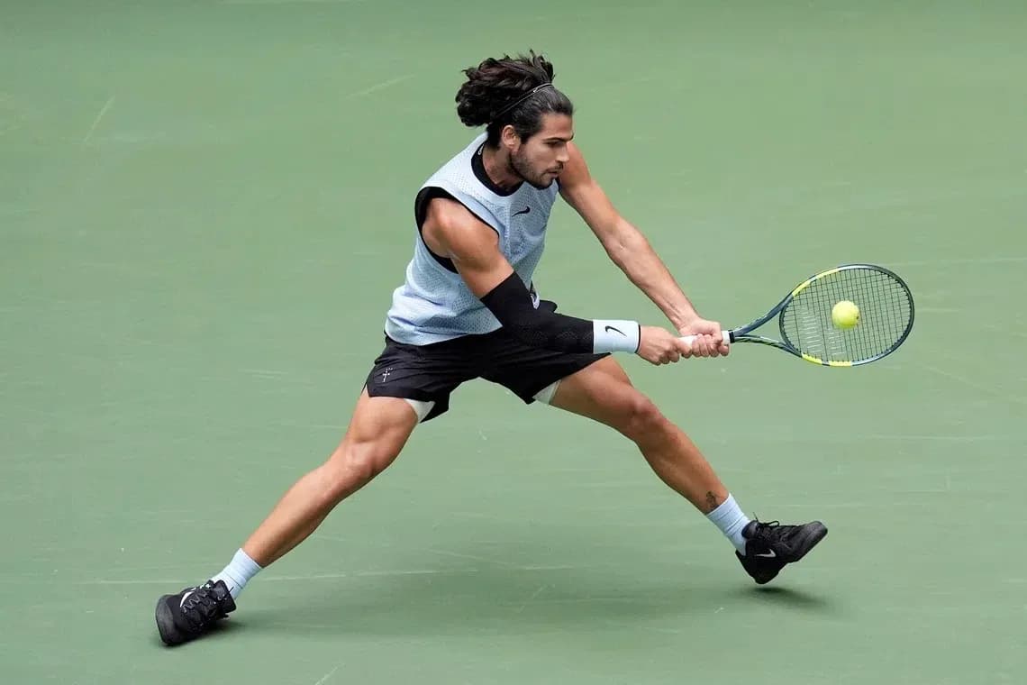 Jugador de tenis golpeando la pelota en la cancha Jugador de tenis golpeando la pelota en la cancha