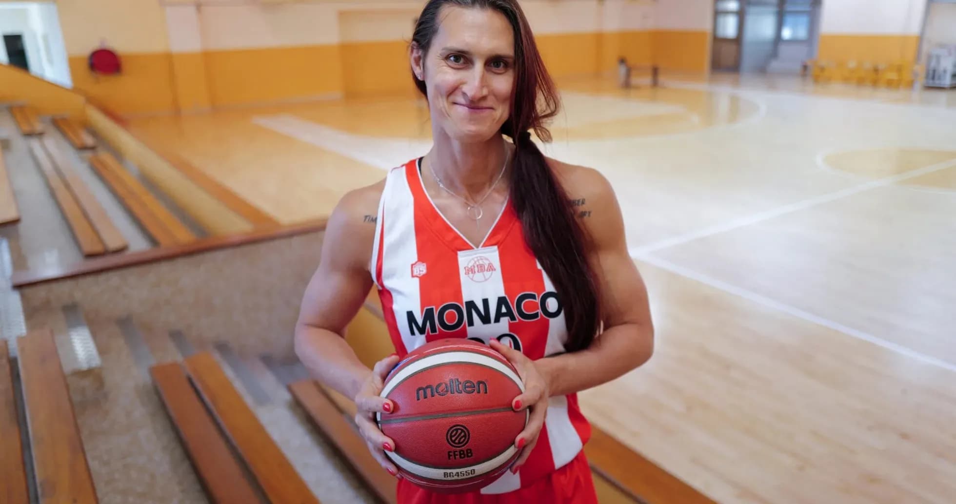 Jugadora de baloncesto con balón en gimnasio Jugadora de baloncesto con balón en gimnasio