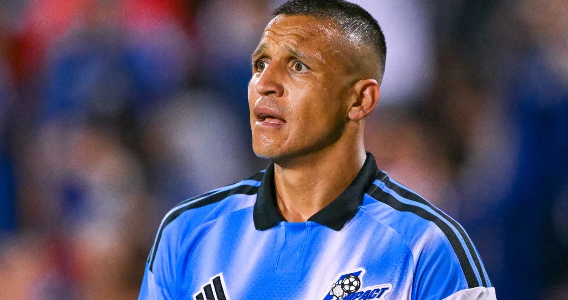 Jugador de fútbol con camiseta azul mirando hacia arriba Jugador de fútbol con camiseta azul mirando hacia arriba