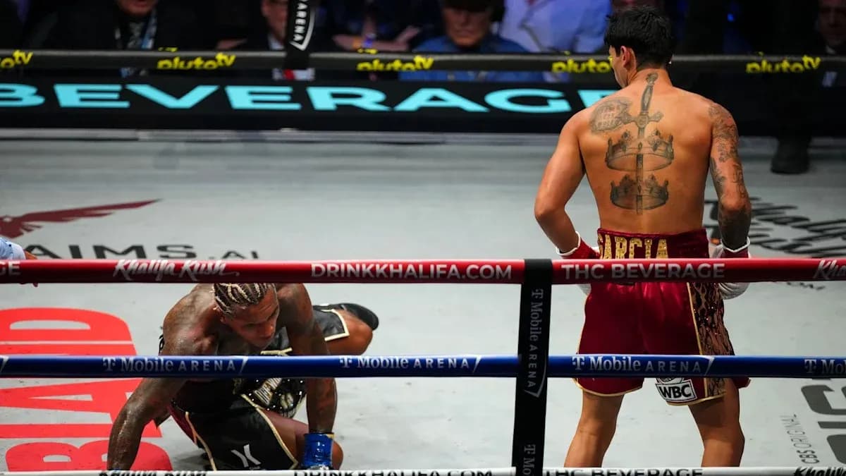 Boxeador en el suelo mientras otro observa Boxeador en el suelo mientras otro observa