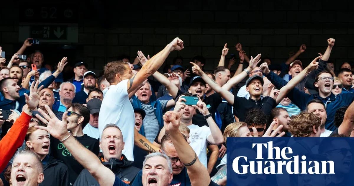 A crowd of fans cheering passionately at a match A crowd of fans cheering passionately at a match