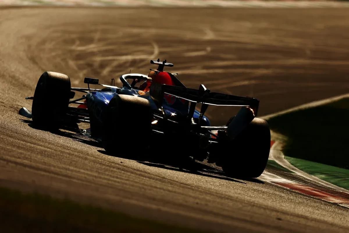 Coche de Fórmula 1 tomando una curva en pista Coche de Fórmula 1 tomando una curva en pista
