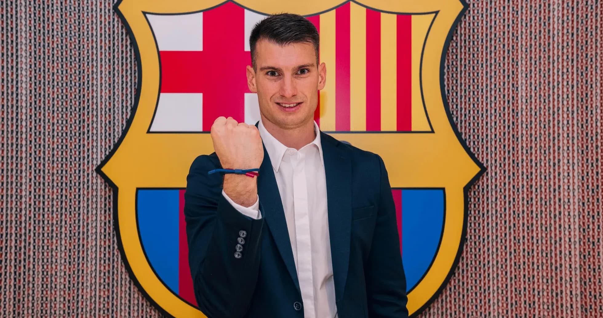 Jugador mostrando el puño frente al escudo del Barcelona Jugador mostrando el puño frente al escudo del Barcelona